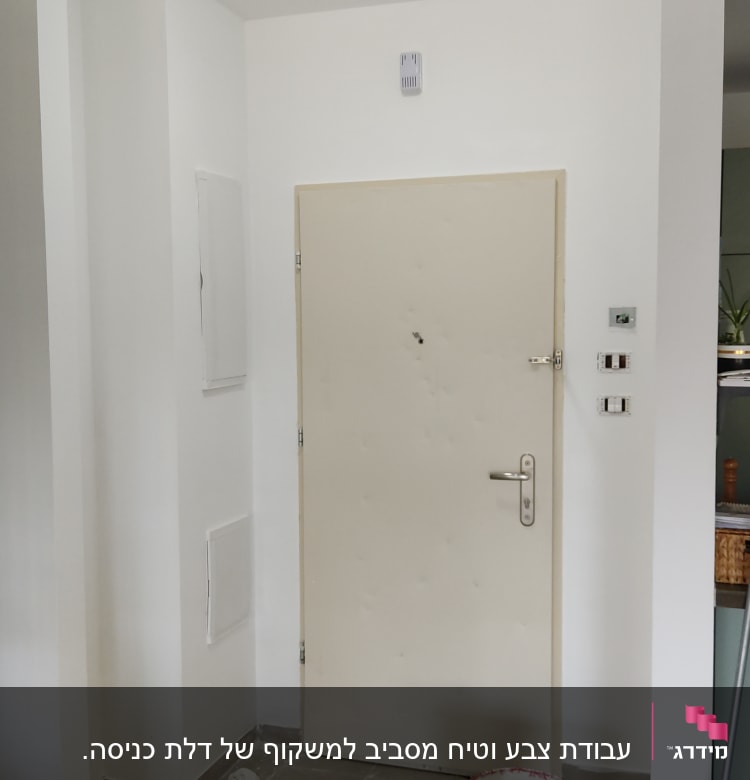 דלת לבנה עם דלי צבע ומברשת על הרצפה